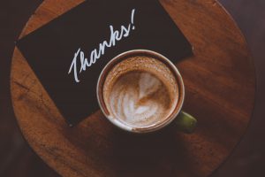 employee appreciation ideas - latte and a thank you note on table flatlay